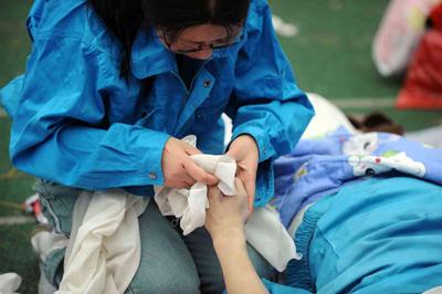 5月14日，張關(guān)蓉在擦拭丈夫譚千秋的遺體。